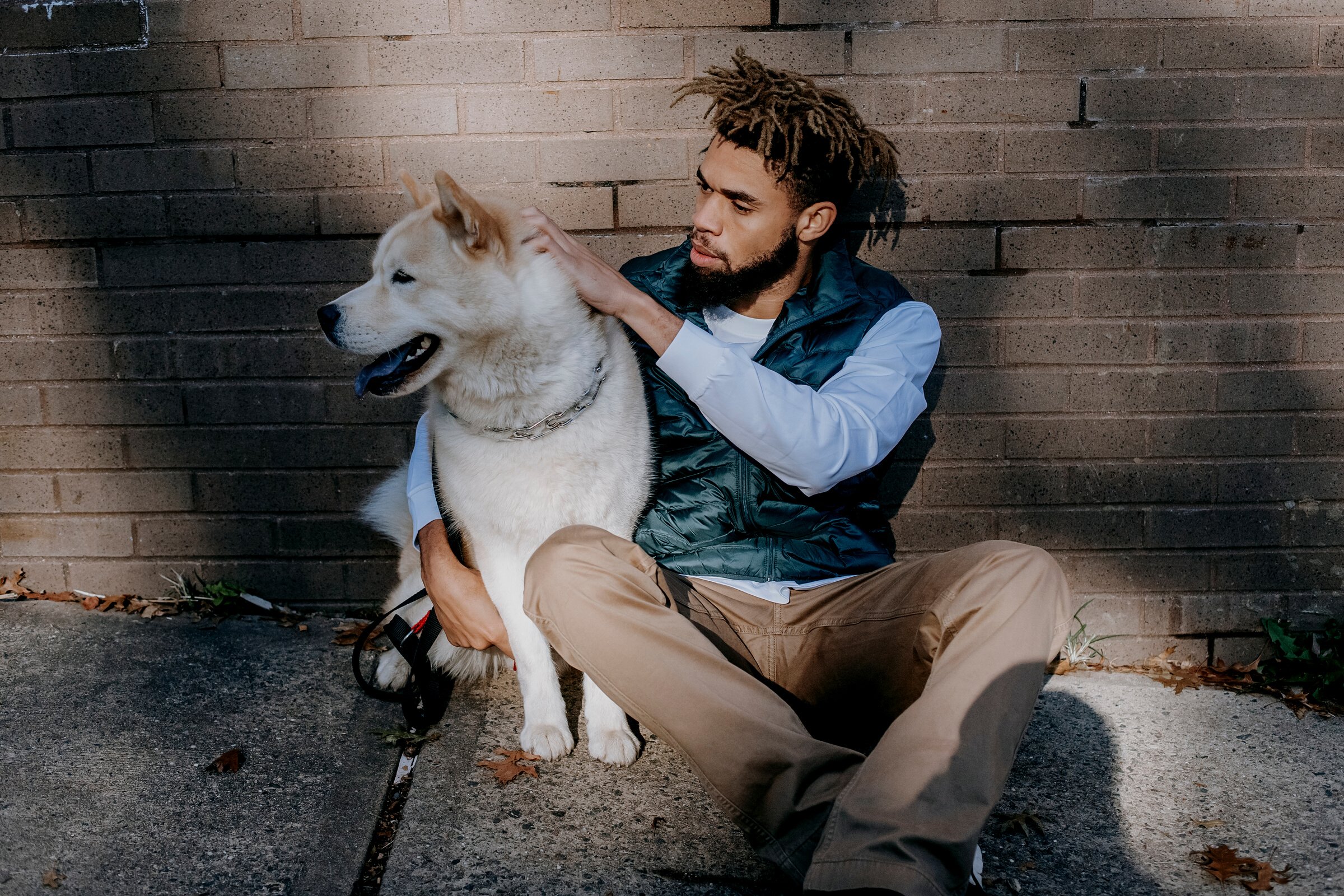 Calm black man petting dog on street